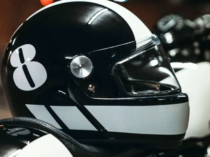 Casco nero con numero 8 bianco e strisce. Per sapere come non far appannare la visiera del casco, guarda questo dettaglio.