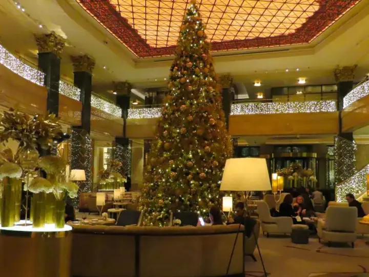 Elegancka wigilia w hotelu. Ogromna choinka i złote dekoracje tworzą świąteczną atmosferę.