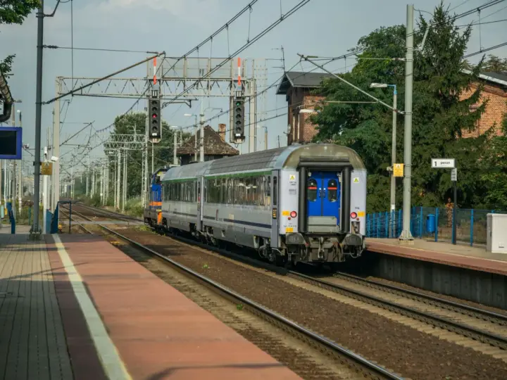 Pociąg Polregio z wygodnymi miejscami siedzącymi stoi na peronie.