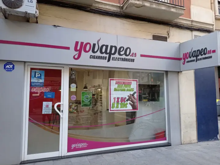 Tienda "yovapeo.es" de cigarros electrónicos. Un cartel anuncia "vaper quema garganta" con ofertas.