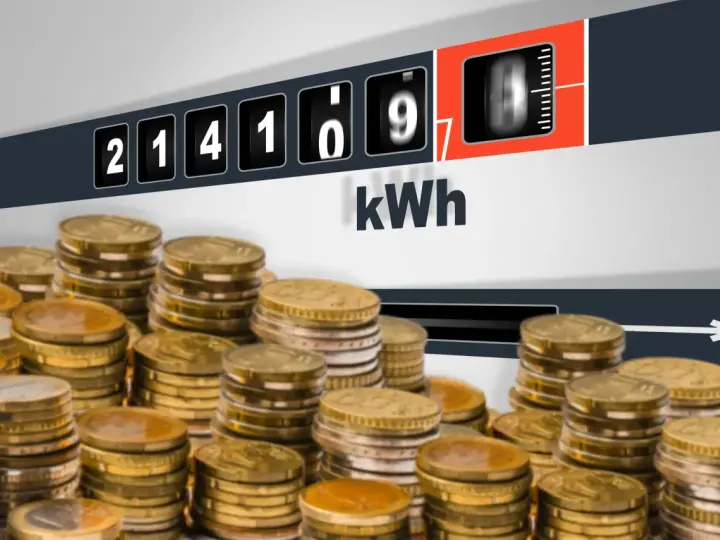 Liczniki energii pokazują zużycie kWh, a stosy monet sugerują pytanie: ile za kWh Tauron?