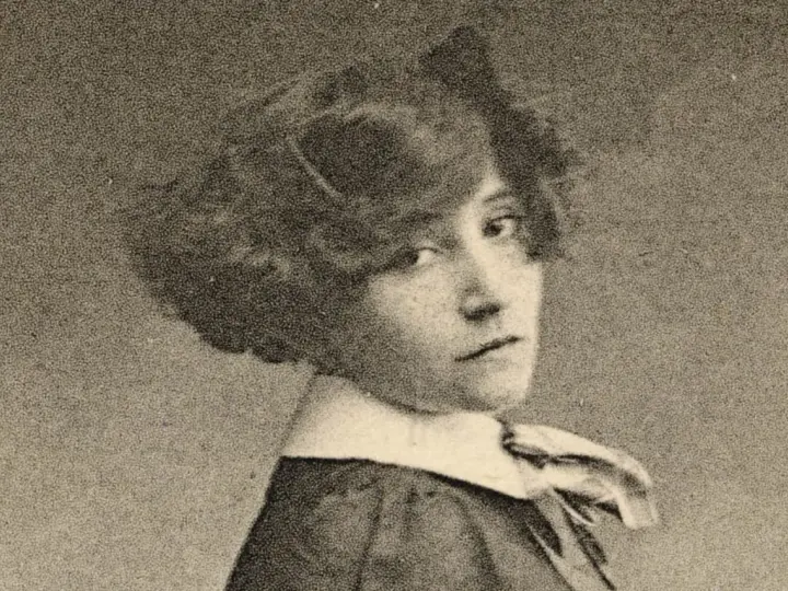 Portrait de Colette jeune, regardant par-dessus son épaule, avec une coiffure bouclée et un col blanc.