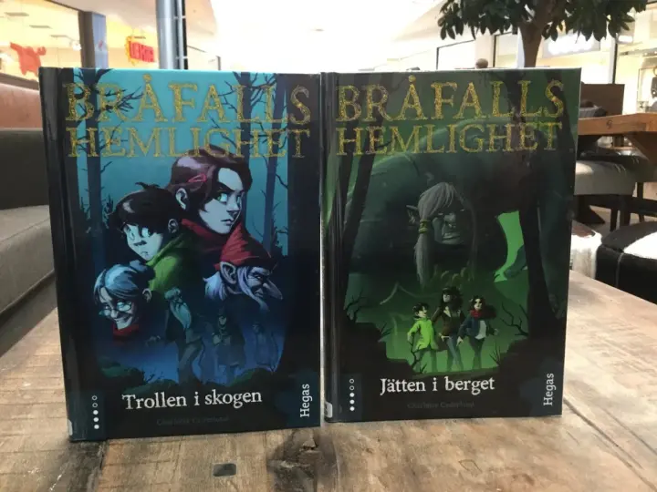 Två böcker, "Trollen i skogen" och "Jätten i berget", med fantasifulla illustrationer. Ett allegori exempel på äventyr.