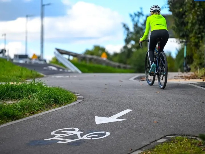 Kobieta na rowerze przemierza malownicze trasy rowerowe Kujawsko-Pomorskie.