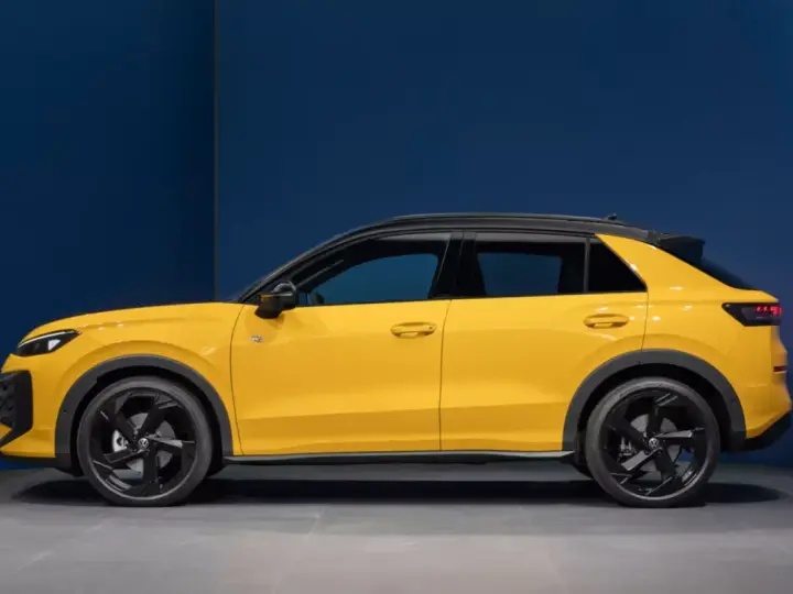 Nowy żółty Volkswagen T-Roc z czarnym dachem, widziany z boku.
