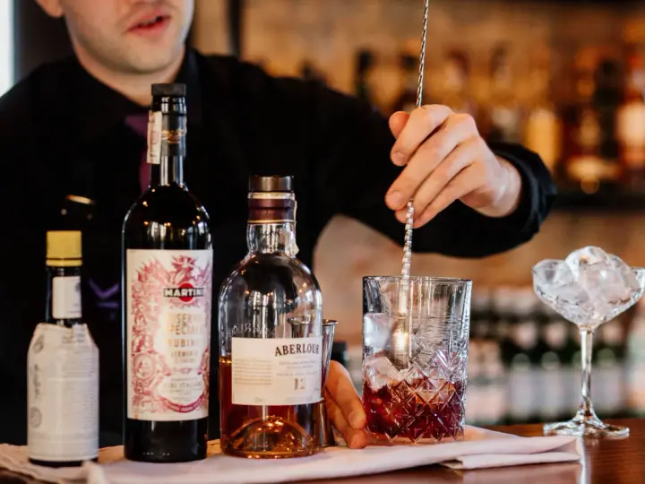 Barman miesza składniki na klasycznego Manhattan drinka. Obok butelki whisky Aberlour i Martini Riserva Speciale Rubino.