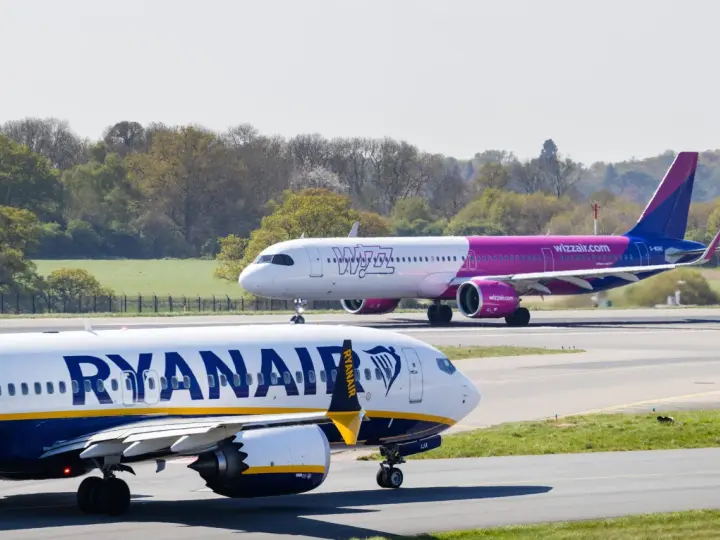 Samolot Ryanair na pierwszym planie, w tle samolot Wizz Air na pasie startowym.