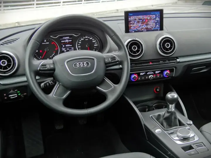 Wnętrze Audi A3 kombi: kierownica, nawigacja, panel klimatyzacji i skrzynia biegów.