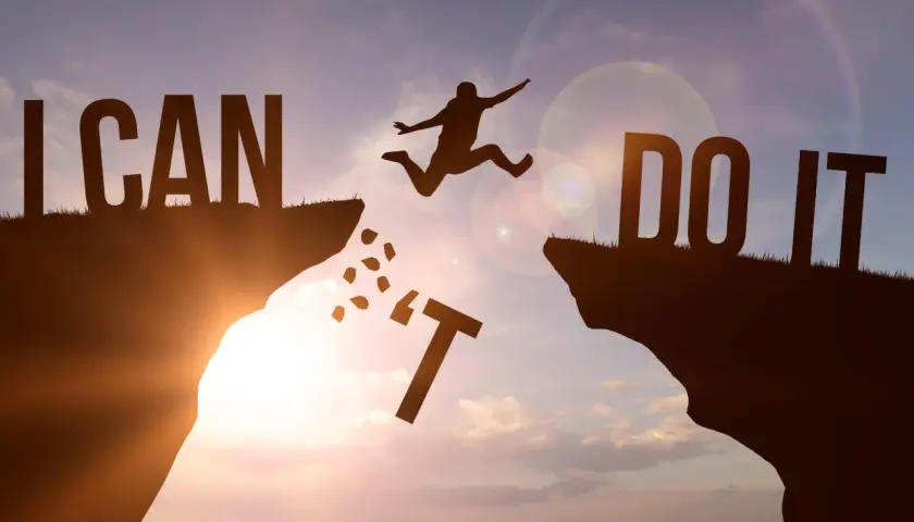 Sylwetka skacze przez przepaść, pokonując przeszkody. Napis "I CAN DO IT" symbolizuje siłę woli i motywację, jak w mądrych cytatach po angielsku.