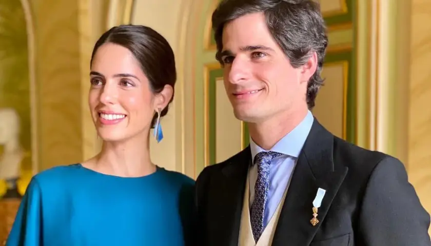 Los duques de Huéscar, sonrientes y elegantes, posan para la foto en un salón de época.