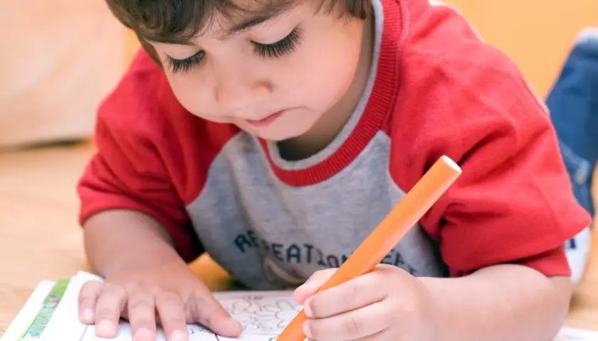 Bambino iperattivo concentrato a colorare, un'idea per cosa fare con un bambino iperattivo.