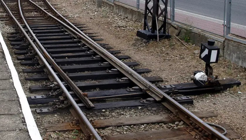 Zwrotnica kolejowa z nastawczym suwakowym mechanizmem. Minimalna droga oporowa klamry w zamknięciu nastawczym suwakowym jest kluczowa dla bezpieczeństwa.
