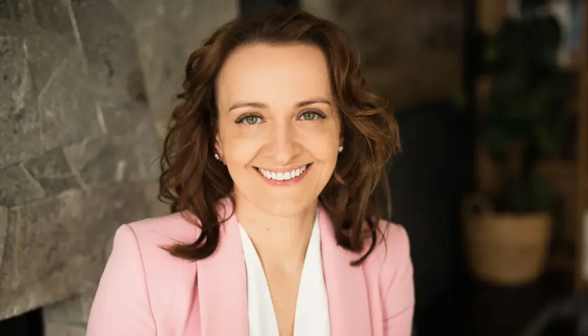 Uśmiechnięta kobieta w różowej marynarce, z burzą brązowych włosów. Czasem zastanawiam się, czy nie wiem czego chcę od życia.