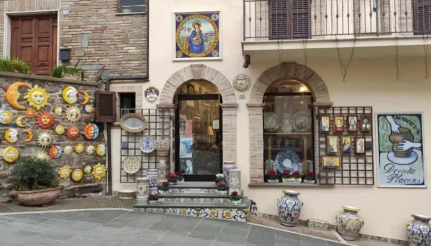 Deruta cosa vedere: bottega di ceramiche con soli, lune, vasi e decorazioni murali.