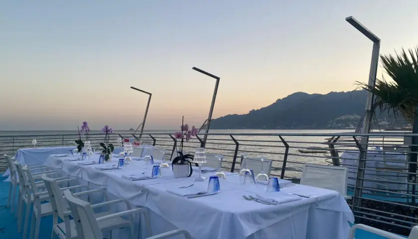 Tavola apparecchiata con vista mare, ideale per cene romantiche nei ristoranti sul mare a Salerno.