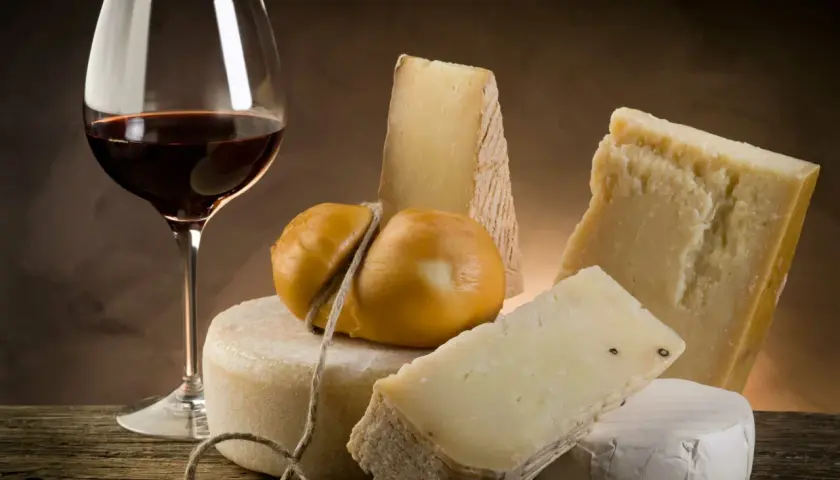 Un verre de vin rouge et une sélection de fromages, un accord parfait pour savoir quel vin avec le fromage.