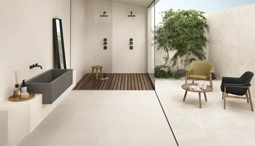 Pavimento casa al mare con vasca in pietra, doccia esterna e zona relax con poltrone.