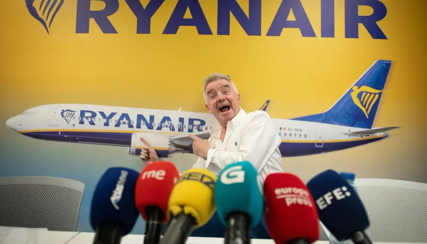 Michael O'Leary z Ryanair, pytany ile kosztuje przebukowanie biletu w Ryanair, wskazuje na samolot.
