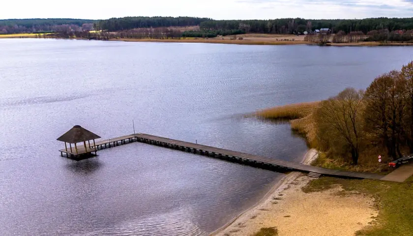 Drewniane molo z altaną na jeziorze w Swornegaciach na Kaszubach. Piękny krajobraz jesienny.