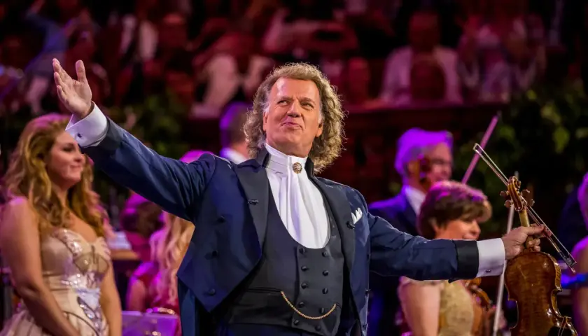 André Rieu w Polsce, dyrygent z wirtuozerską skrzypaczką wita publiczność.