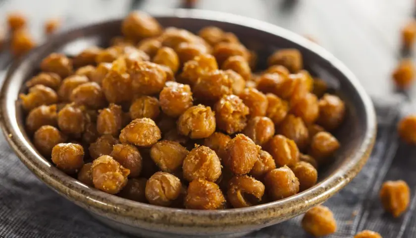Un tazón lleno de garbanzos fritos crujientes y dorados, perfectos para un snack saludable.