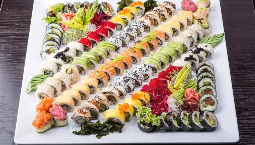 Ogromna taca sushi z różnymi rolkami, idealna do wyboru z menu Mizumi Sushi. Kolorowe składniki i estetyczne ułożenie.