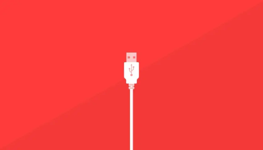 Un conector blanco de varios tipos USB se alza sobre un fondo rojo vibrante, listo para conectar.