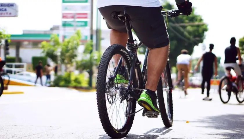 Rowerzysta w jaskrawozielonych butach jedzie ulicą. W tle widać stację benzynową. Dowiedz się, jak ustawić licznik rowerowy, by śledzić swoje trasy.