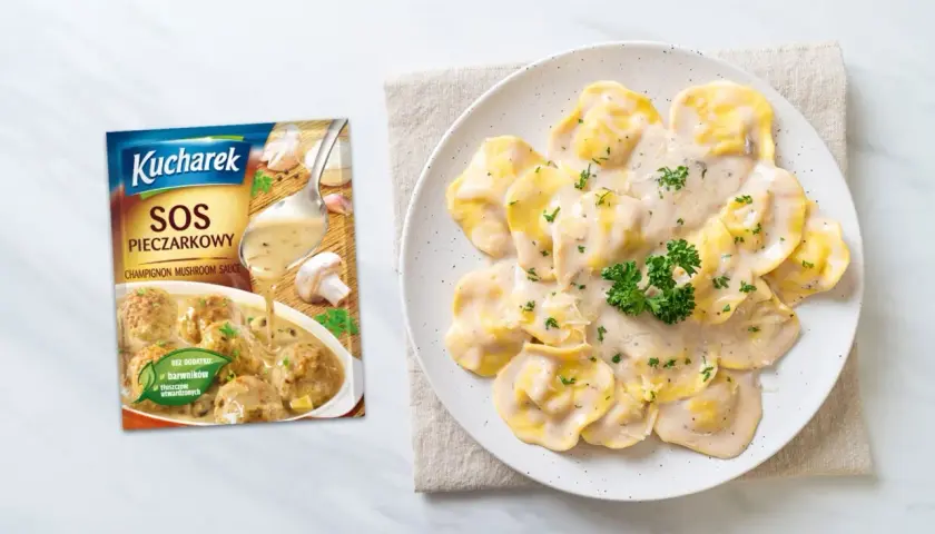 Ravioli polane kremowym sosem pieczarkowym, obok opakowanie sosu Kucharek.