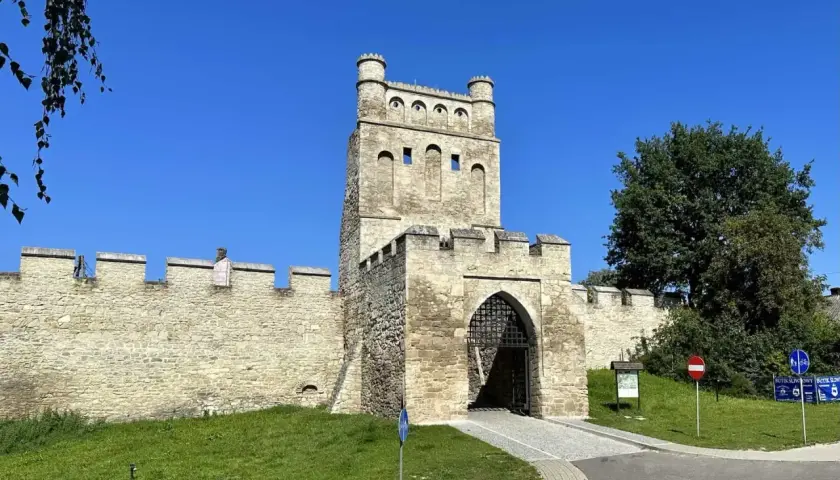 Kamienna brama z wieżą, otoczona murami obronnymi, przypomina polskie Carcassonne.