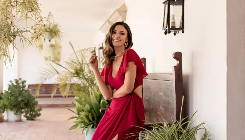 Elegante invitada con semirecogido, ideal para peinados para comunión invitada. Vestido rojo y sonrisa radiante.