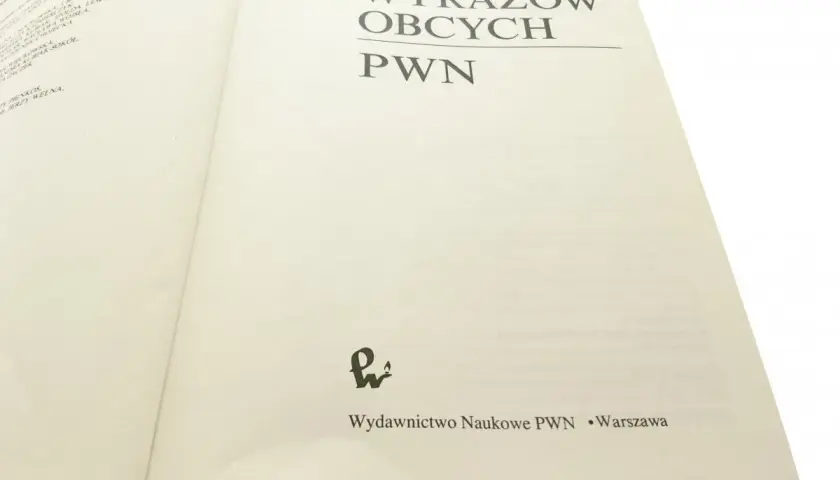 Otwarta książka "Słownik Wyrazów Obcych PWN" z widocznym tytułem i logo wydawnictwa.