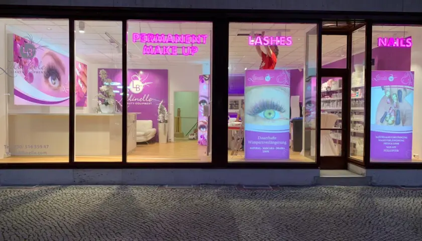 Kosmetikstudio mit Leuchtreklamen für Permanent Make-up, Lashes und Nails.