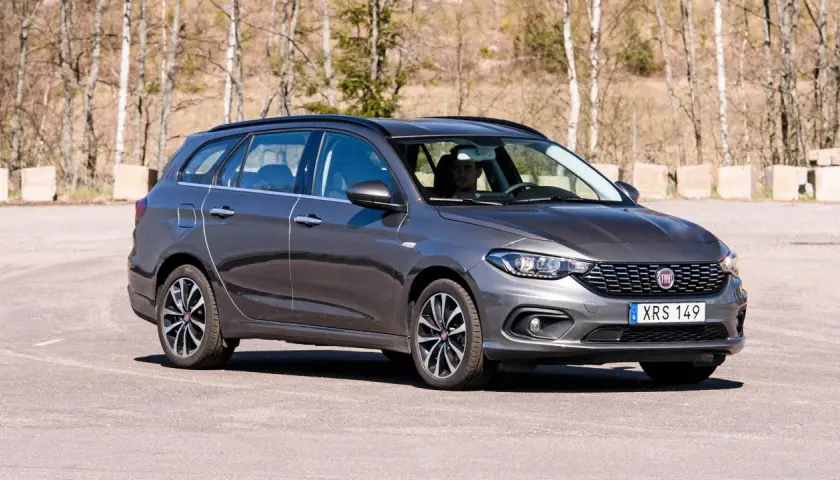 Grå Fiat Tipo kombi parkerad utomhus. En man sitter bakom ratten.