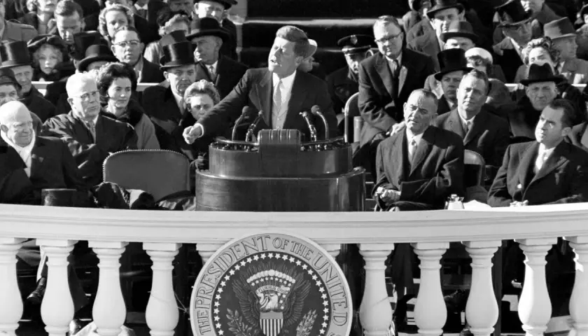 John F. Kennedy's inspiring **leadership style** is evident as he addresses a crowd, embodying youthful vigor and a call to action.
