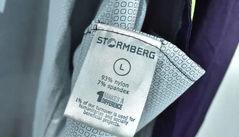 Metka odzieży marki Stormberg, firmy wspierającej projekty humanitarne. Rozmiar L, skład 93% nylon, 7% spandex.
