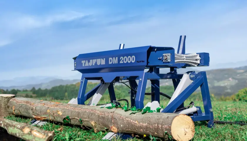 Der Tajfun DM 2000, ein Holzspalter, steht bereit, um Baumstämme im Freien zu bearbeiten.