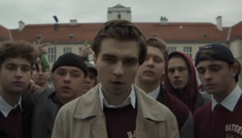 Grupa młodych ludzi, w tym chłopak w beżowej kurtce, zastanawia się, ile lat ma Mata.