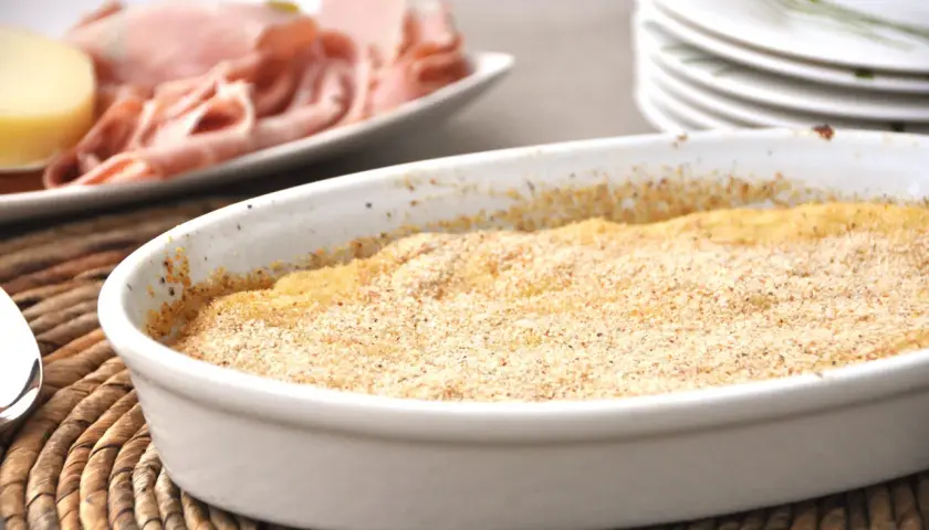 Gateau di patate Bimby appena sfornato, dorato e croccante, pronto per essere gustato con affettati e formaggio.
