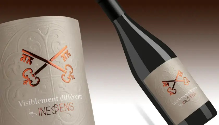Étiquette de vin avec deux clés croisées, évoquant une pyramide classification des vins. Le texte "Visiblement différent by INESPENS" est présent.