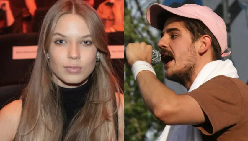 Dziewczyna z długimi blond włosami obok Taco Hemingwaya śpiewającego do mikrofonu.