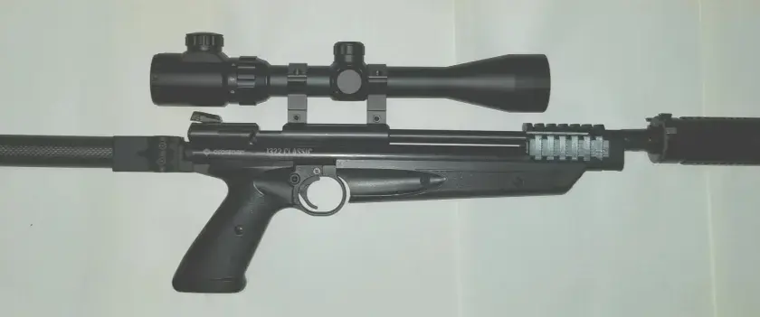 Crosman 1322 z lunetą i tłumikiem, gotowy do akcji.