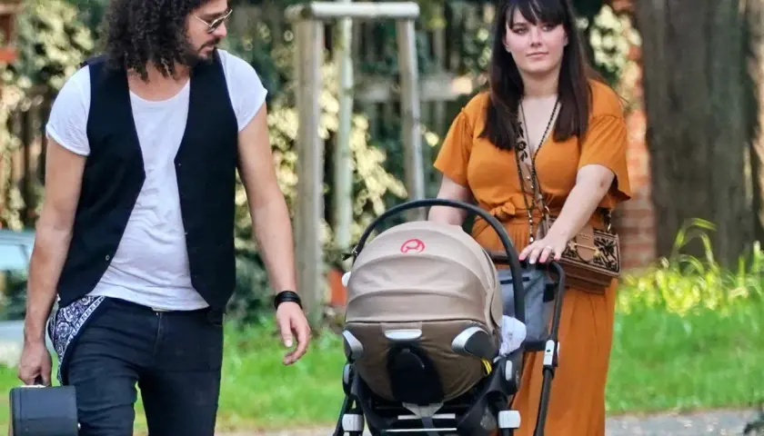 Ewa Farna z partnerem i wózkiem dziecięcym spacerują po parku.