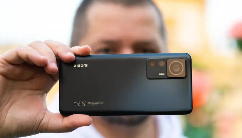 Dłoń trzyma czarny smartfon Xiaomi z widocznym modułem aparatów.