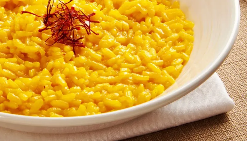 Aksamitne risotto alla milanese, bogato zdobione nitkami szafranu, kusi swoim złocistym kolorem i kremową konsystencją.