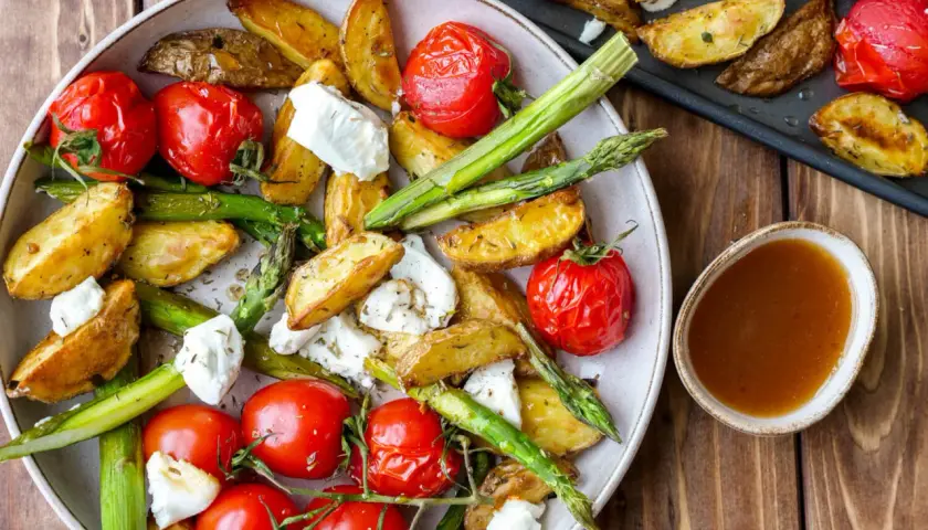 Geröstete Kartoffelspalten, Kirschtomaten und grüner Spargel mit Feta. Ein köstliches Gericht, das sich gut für Spargel Rezepte eignet.