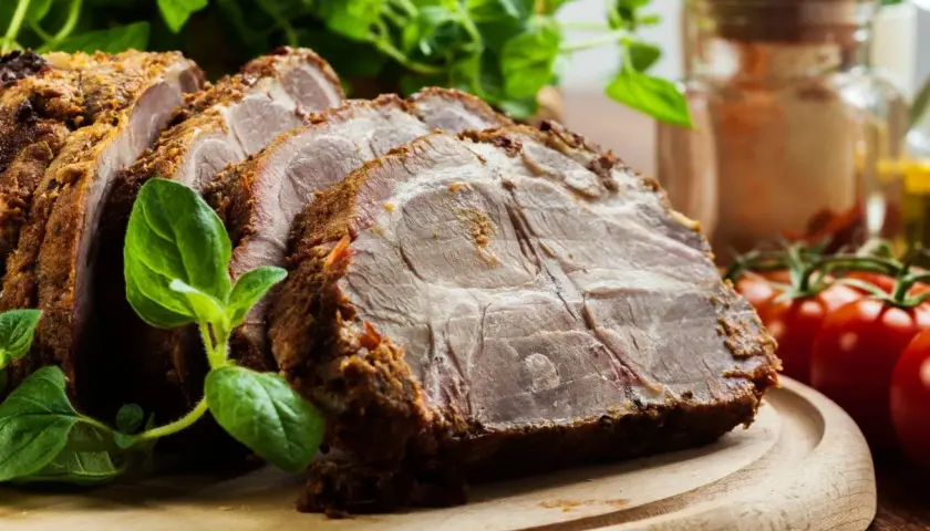 Rozpływająca się karkówka z piekarnika, soczysta i aromatyczna, podana z ziołami i pomidorkami.