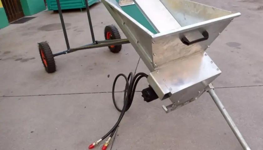 Ein mobiler **förderband hydraulisch** mit Metalltrichter und Rädern, bereit für den Einsatz.