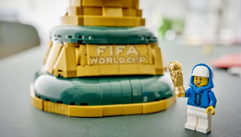 Ein Lego-Männchen mit FIFA-Hoodie hält stolz den goldenen Pokal des Lego World Cup.