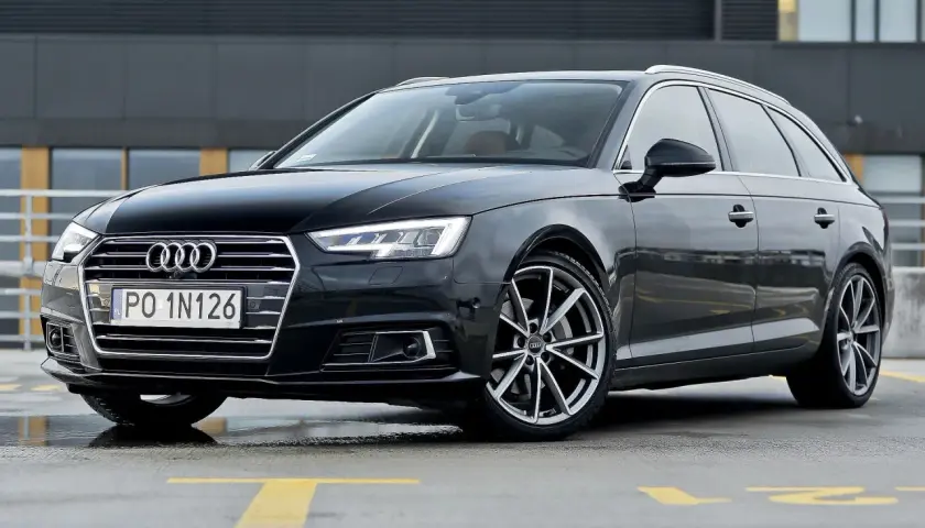 Czarny Audi A4 Avant z tablicą PO 1N126 na parkingu.